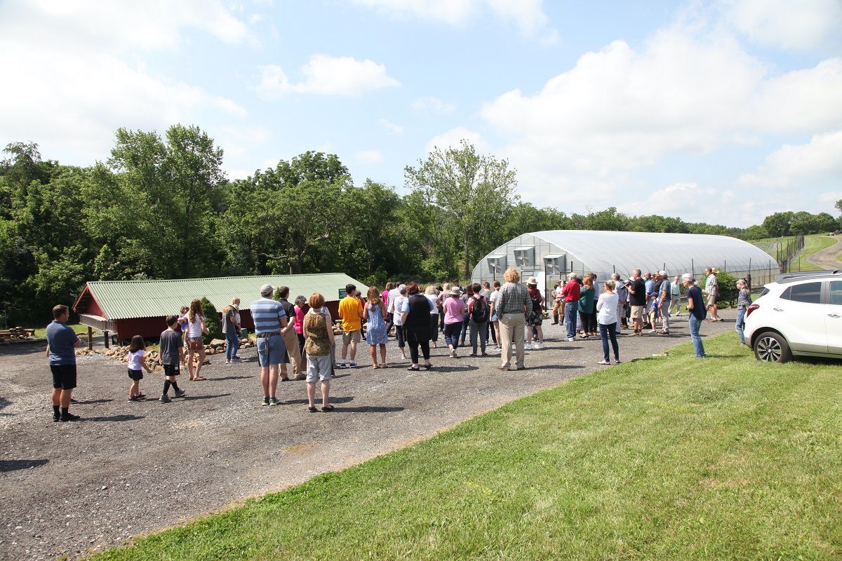 50+ people standing in front of the new  greenhouse for the ribbon cutting ceremony