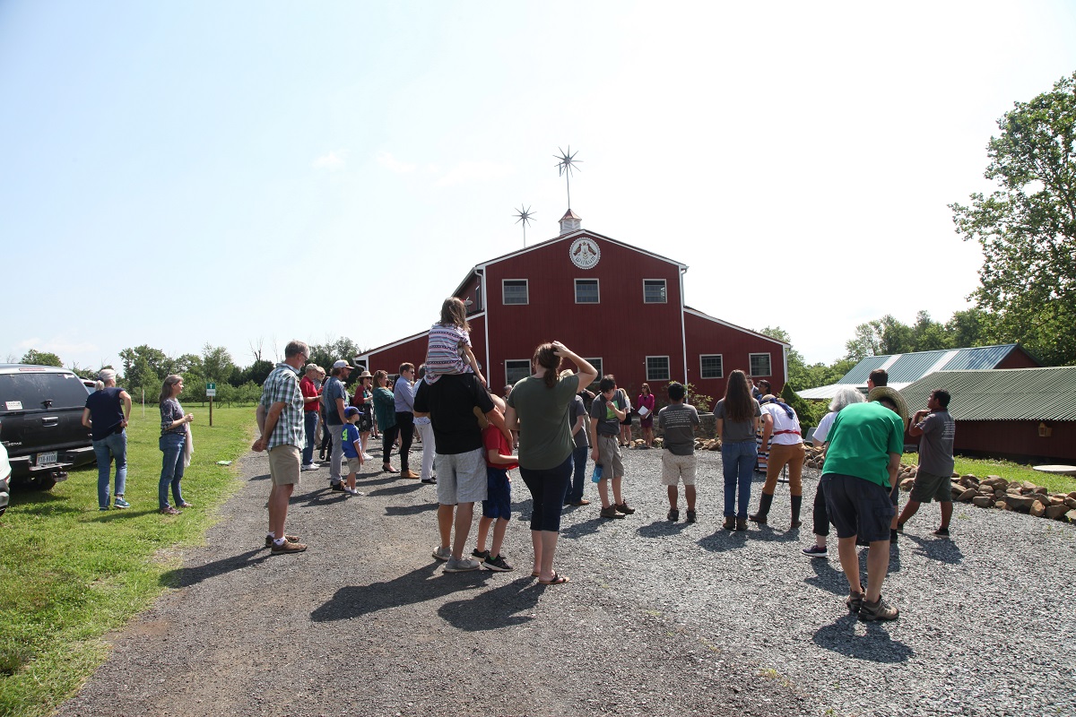 50 people standing in front of the Red Barn gathering for the ribbon ceremony
