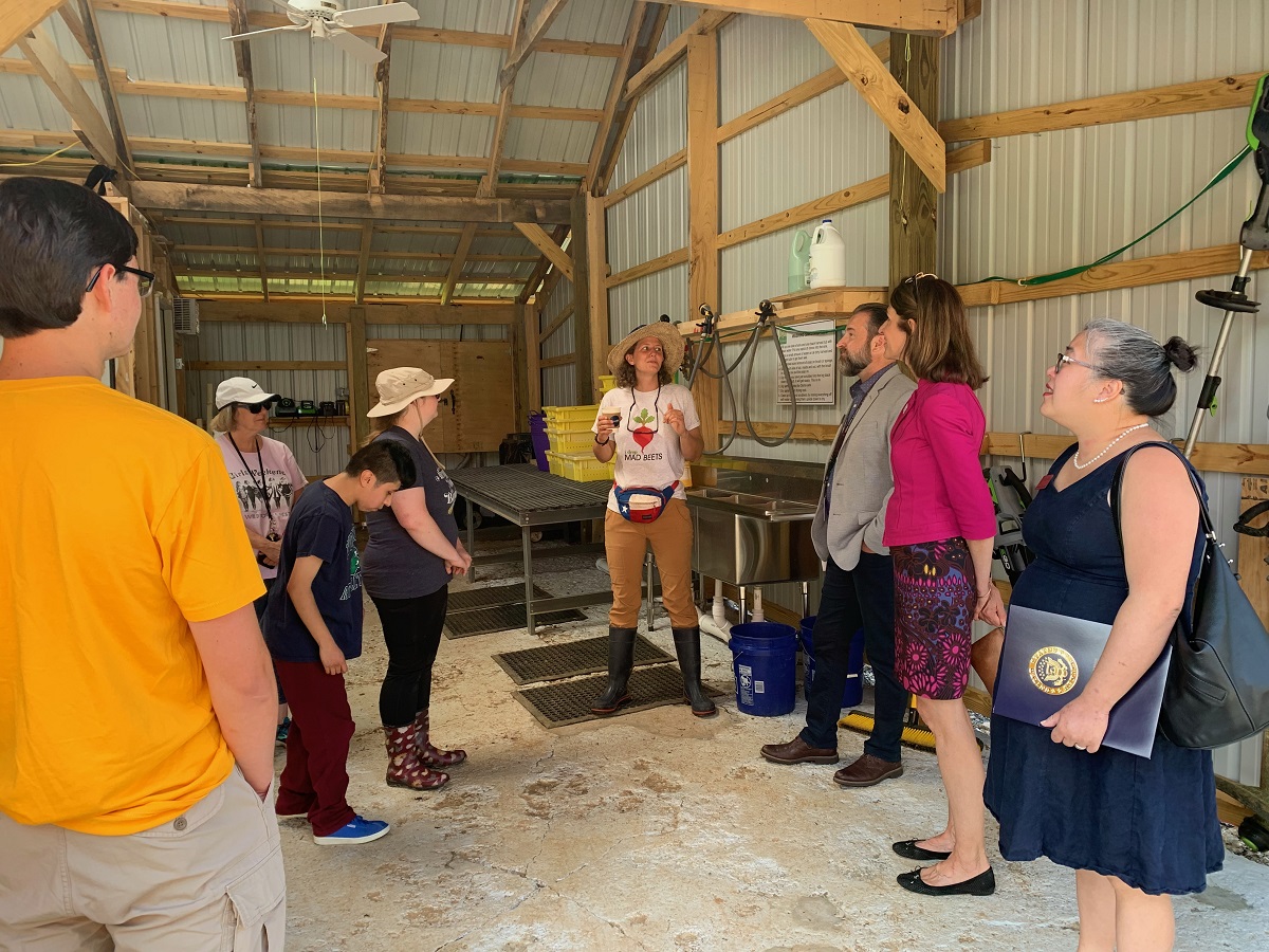The Farm Manager showing the wash station inside the barn.  Hoses are hanging above Wash sinks