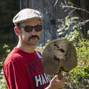 Common Roots Farm CA 2 Man wearing sunglasses and hat holding shovel