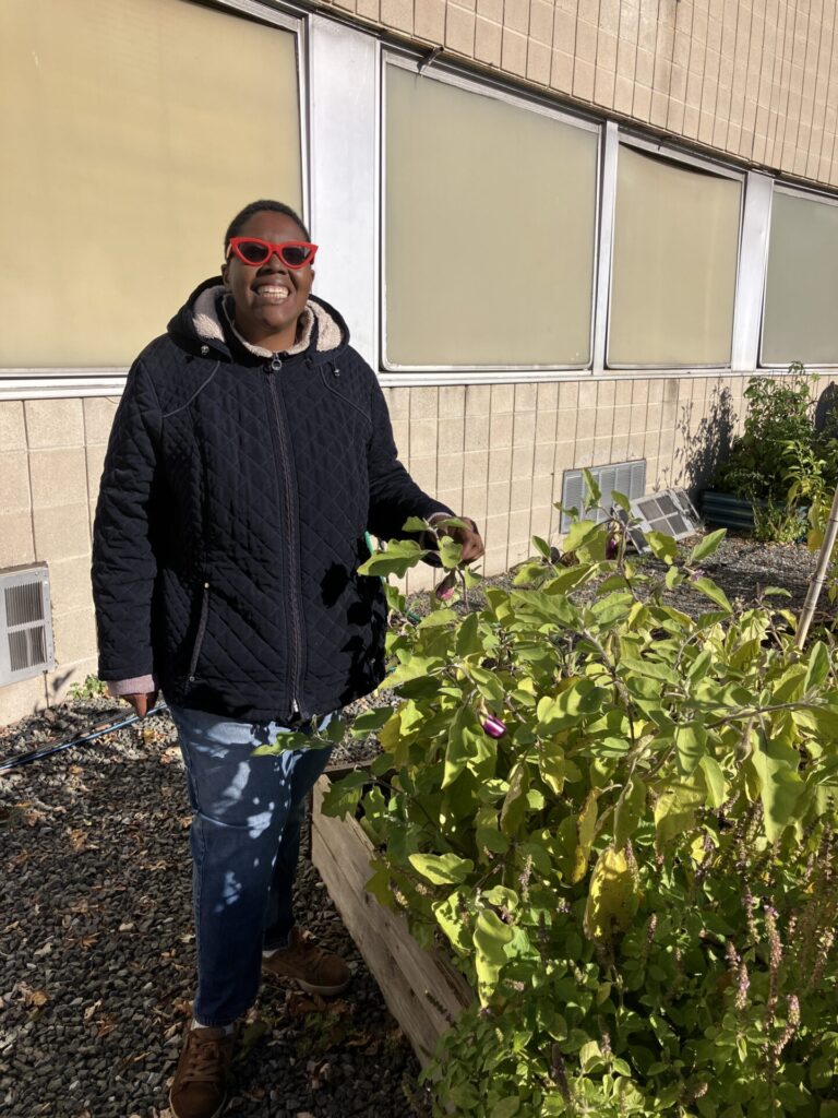 Person standing with eggplants
