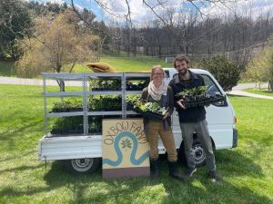 2 people standing in front of plant truck with Oxbow Farm sign