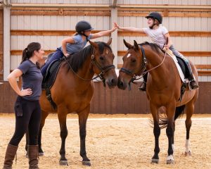 Rainbow Riding 1 Kids on horses high-fiving each other